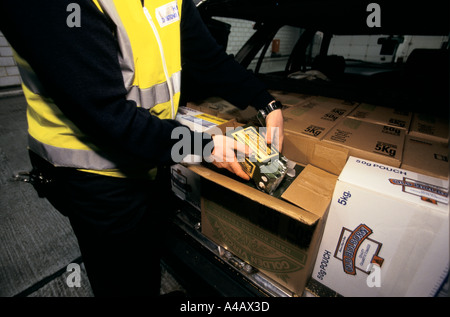 Un AGENT DES DOUANES ET ACCISE, port de Douvres SUR LA CÔTE SUD DE L'ANGLETERRE on confisque les biens des catalogues d'un passeur. Banque D'Images