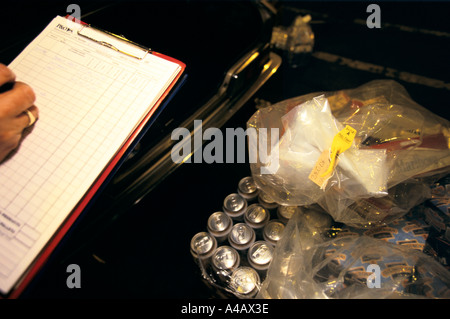 Un AGENT DES DOUANES ET ACCISE, port de Douvres SUR LA CÔTE SUD DE L'ANGLETERRE on confisque les biens des catalogues d'un passeur. Banque D'Images