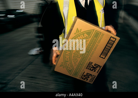 Un AGENT DES DOUANES ET ACCISE, port de Douvres SUR LA CÔTE SUD DE L'ANGLETERRE on confisque les biens des catalogues d'un passeur. Banque D'Images