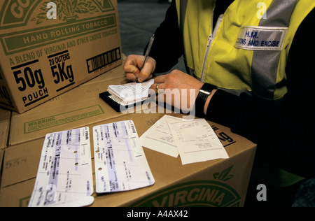 Un AGENT DES DOUANES ET ACCISE, port de Douvres SUR LA CÔTE SUD DE L'ANGLETERRE on confisque les biens des catalogues d'un passeur. Banque D'Images