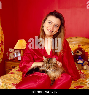 Patricia actrice Penrose sur son lit avec son fluffy cat Banque D'Images