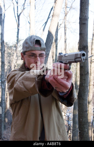 Femme à la cible, visant son semi-automatique, .45 ACP, dans le poing. Banque D'Images