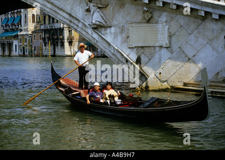 Gondola avec les touristes japonais passer sous bridge Venise Italie Banque D'Images