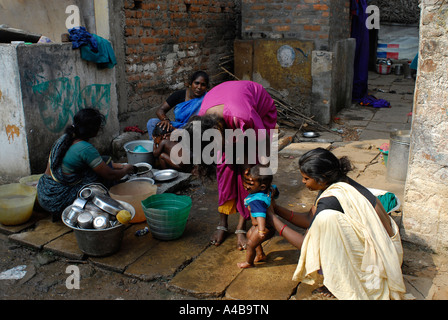 Image de mère Dalit echelle baby boy au puits communautaire dans le Jagathapuram bidonville à Chennai Tamil Nadu Inde Banque D'Images