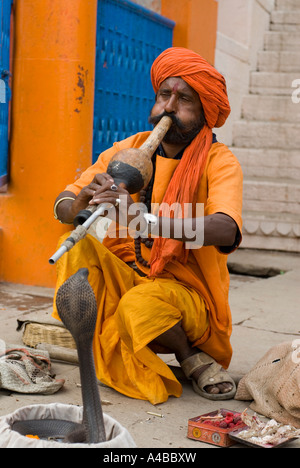 Image d'un charmeur de serpent jouant pour son cobra se balançant sur un ghat de Varanasi Inde Banque D'Images