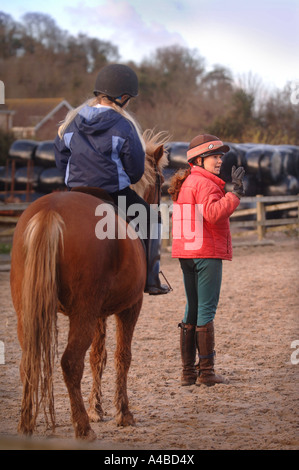 Un instructeur de l'ÉCOLE D'ENSEIGNEMENT LES À SE RENDRE À UNE ÉCOLE D'ÉQUITATION SOMERSET UK Banque D'Images