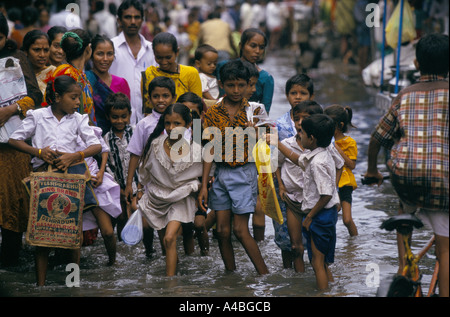 Histoire de la mousson, de l'inde', à Bombay. Les enfants retournent à la maison de l'école à travers les rues inondées du bidonville de Dharavi, 1999 Banque D'Images