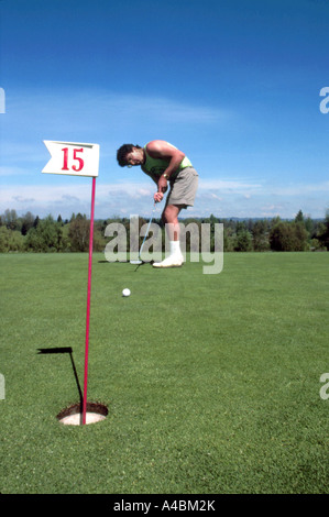 Male Golfer putting on Practice Green Banque D'Images