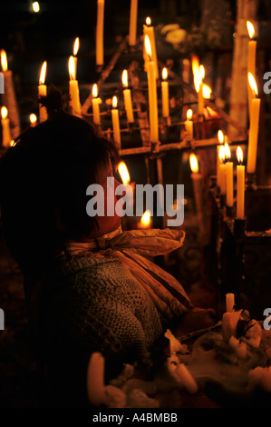 Le Pérou. Jeune fille et bougies votives dans une église. Banque D'Images