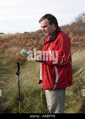 Capture d'un homme générique Walker à l'aide d'un système de navigation GPS portable sur une randonnée côtière à Whitecraigs près de North Berwick Banque D'Images