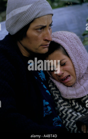 Col CHUBERI, GÉORGIE, octobre 1993 : une mère réconforte sa fille, attendre que l'échange de feu avec des bandits locaux des soldats gouvernementaux autour de la prochaine courbe dans le sentier de montagne. Banque D'Images