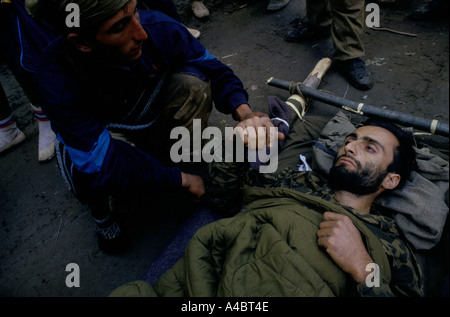 Col CHUBERI, GÉORGIE, octobre 1993 : un soldat du gouvernement se trouve sur un streatcher en attente d'aide médicale après qu'il a été abattu par des bandits locaux après avoir refusé de remettre ses armes. Banque D'Images