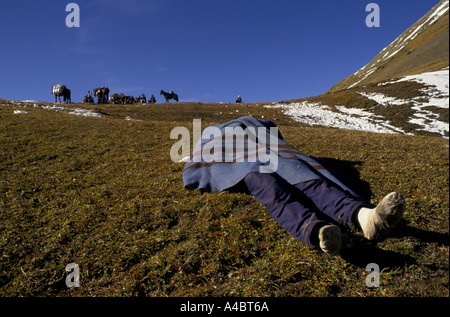 Col CHUBERI, GÉORGIE, octobre 1993 : une couverture couvre le corps des morts sur le col des réfugiés Chuberi comme d'autres avec des chevaux de bât chargé sur push. Banque D'Images