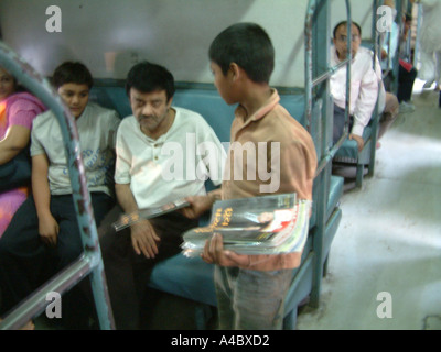 Les enfants indiens98482 SOA la vente des magazines dans le train, qui vivent et travaillent sur la gare centrale de Bombay Mumbai Inde Banque D'Images