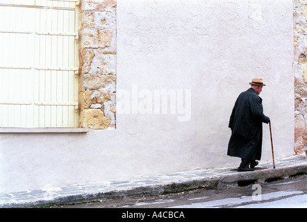 Vieil homme marcher sur l'asphalte avec de légères acclivity, Chania, Crete, Grèce des sentiers à Tissiniva Banque D'Images