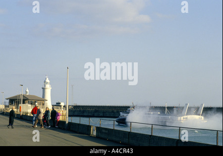 PROMENADE CÔTIÈRE SUR LA FAMILLE REGARDER UN AÉROGLISSEUR DE PRENDRE LES PASSAGERS À QUITTER LA FRANCE À PARTIR DE LA CIRCULATION PRÈS DU PORT DE DOUVRES, EN ANGLETERRE Banque D'Images
