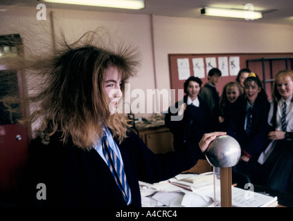 Un jeune élève AYANT UNE EXPÉRIENCE DE COLLECTE DE CHEVEUX EN TOUCHANT LE VAN DER GRAAF GENERATOR qui développe une charge électrostatique. Classe de sciences au secondaire de Holyrood à Glasgow Banque D'Images