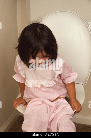 Petite fille assise sur les toilettes Banque D'Images