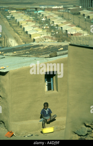 Un enfant assis devant son domicile, Qwa Qwa homelands, Afrique du Sud, 1980 Banque D'Images