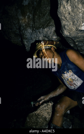 Un chercheur d'or avec une torche attaché à son hard-hat travaillant une couture dans un tunnel souterrain, le Mont Diwata, Mindanao, la Phil Banque D'Images