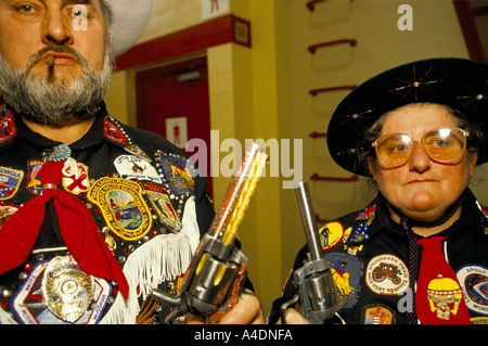 Un couple de fans montrant outre de leurs pistolets à la musique country et western Festival à Wembley, Londres Banque D'Images