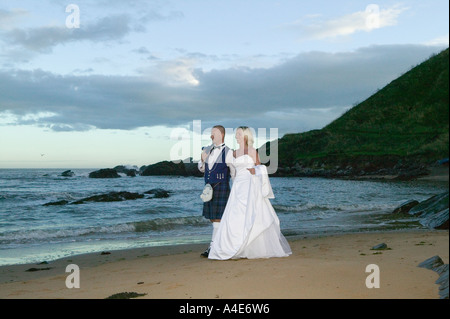 Bride & Groom marche sur le rivage Banque D'Images
