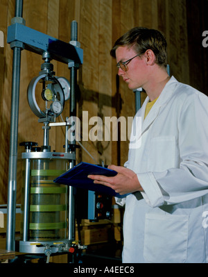 Technicien effectuant un test de compression triaxiale sur un échantillon de sol Banque D'Images