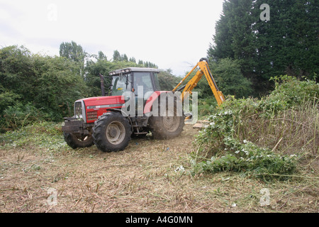 Travailleur agricole débroussaillage préventif sur les terres agricoles. Banque D'Images