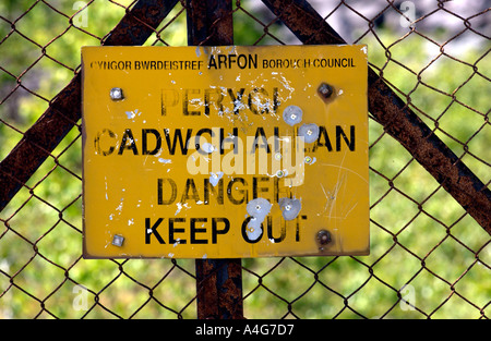 Langue Bilingue Anglais gallois le signe de danger sur une ancienne carrière d'ardoise près de Llanberis Gwynedd Snowdonia dans le Nord du Pays de Galles UK Banque D'Images