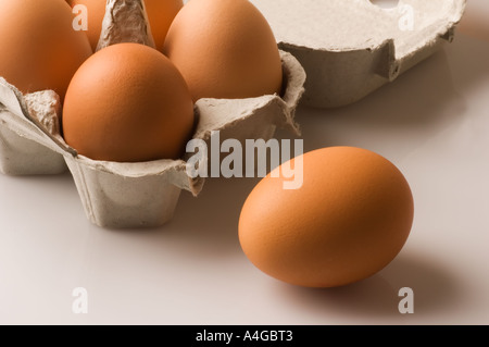 Un seul oeuf à côté d'une case sur une surface plate Banque D'Images