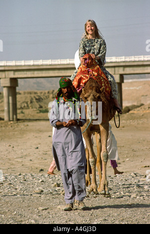 Sind Pakistan Karachi touristes occidentaux sur Camel à Paradise Point Beach Banque D'Images