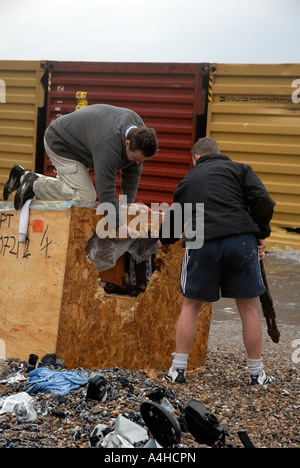 Les hommes s'ouvrir une caisse échoués après le MSC Napoli cargo s'est échoué au large de Branscombe, Devon en Grande-Bretagne UK Banque D'Images