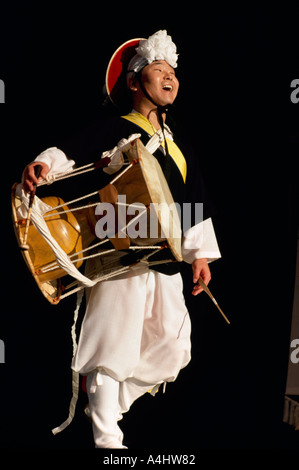 Un batteur de la Troupe Samul Nori en provenance de Corée effectuant sur un tambour Changgo Banque D'Images