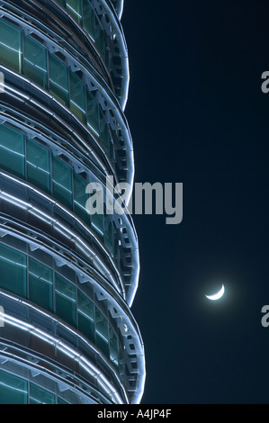 Détail de la Tour 1242 à Kuala Lumpur la nuit avec un croissant de lune derrière. Banque D'Images