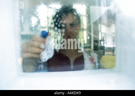 Woman cleaning window Banque D'Images