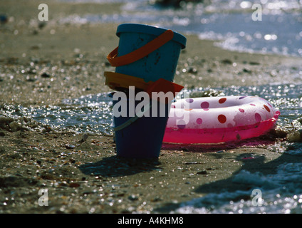 Seaux et anneau gonflable sur la plage Banque D'Images