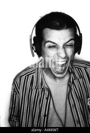 Man listening to headphones la bouche grande ouverte, portrait Banque D'Images