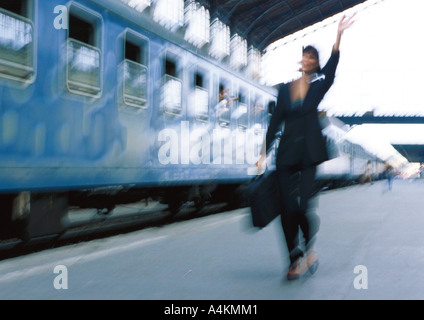 Businesswoman next to train, forme, blurred Banque D'Images