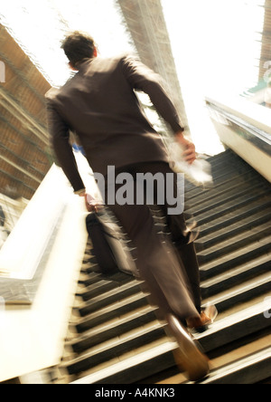 Businessman se dépêcher vers le haut des escaliers de la Gare, Vue arrière, blurred motion Banque D'Images