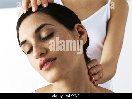 Femme avec les yeux fermés recevoir massage du cou, close-up Banque D'Images