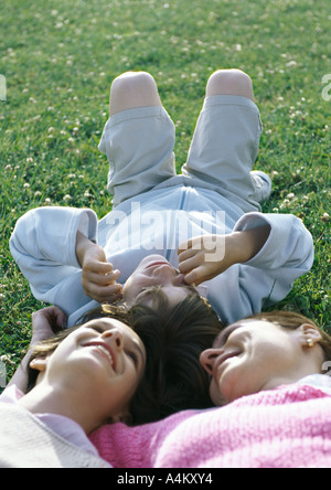 Mère couchée sur l'herbe avec garçon et fille, tête-à-tête Banque D'Images