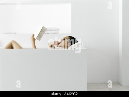 Femme lisant dans une baignoire Banque D'Images