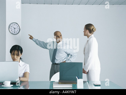 Boss pointing at réveil et à la regardée en employé Banque D'Images