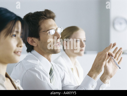 Les gens d'affaires à atteindre, l'Homme à lunettes gesturing Banque D'Images