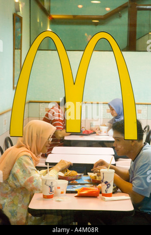 Un couple musulman prendre un hamburger dans un restaurant McDonalds halal à Kuching Sarawak Banque D'Images