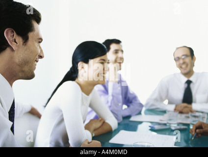Businesspeople sitting around table ensemble, rire Banque D'Images