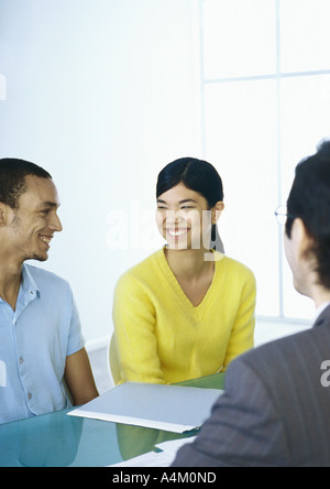 Man and Woman smiling, assis dans le tableau de businessman Banque D'Images