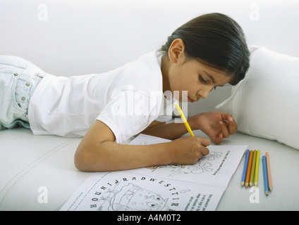 Girl lying on stomach sur canapé, couleur Banque D'Images