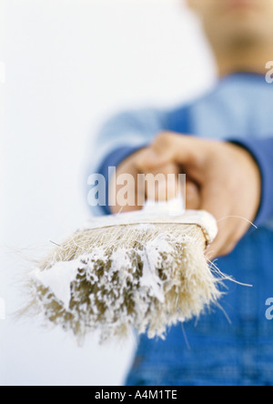 Man holding out paintbrush, close-up de paintbrush Banque D'Images