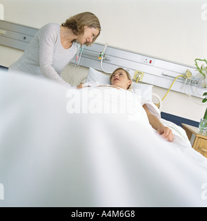 Syndicat talking to patient in hospital bed Banque D'Images